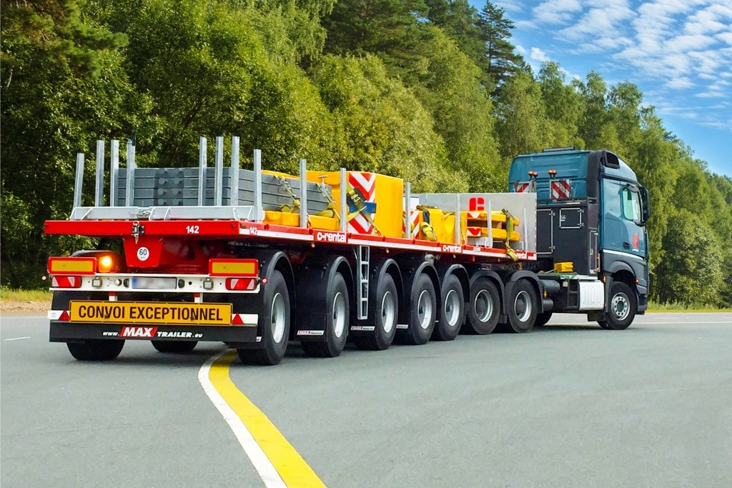 Ballast flatbed trailers transport heavy crane parts and counterweights.